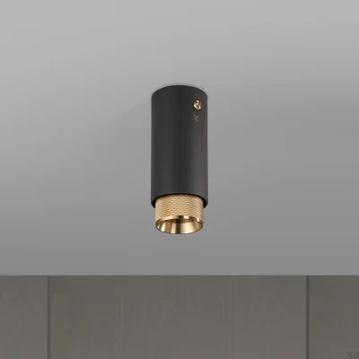 Spot encastré en forme de croix, en acier graphite avec finition laiton.